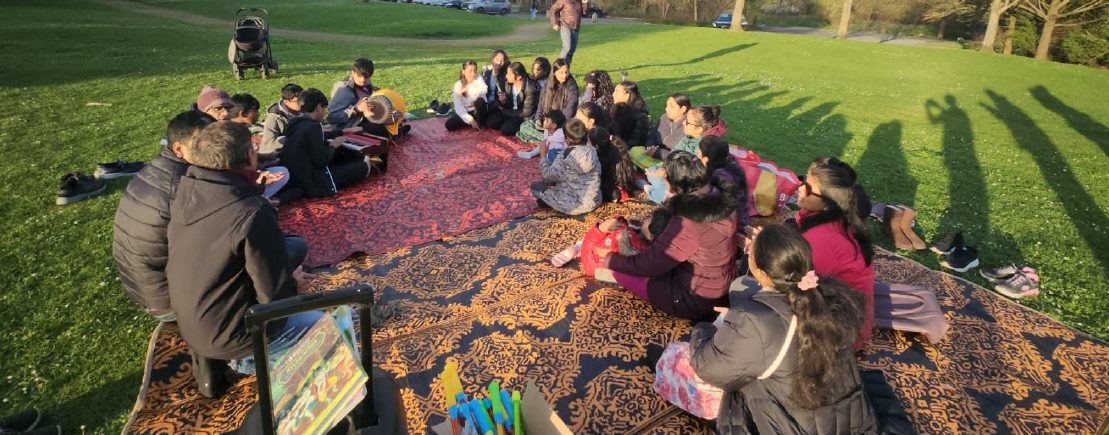 Devotees seated together for an outdoor Bhakti Vriksha picnic