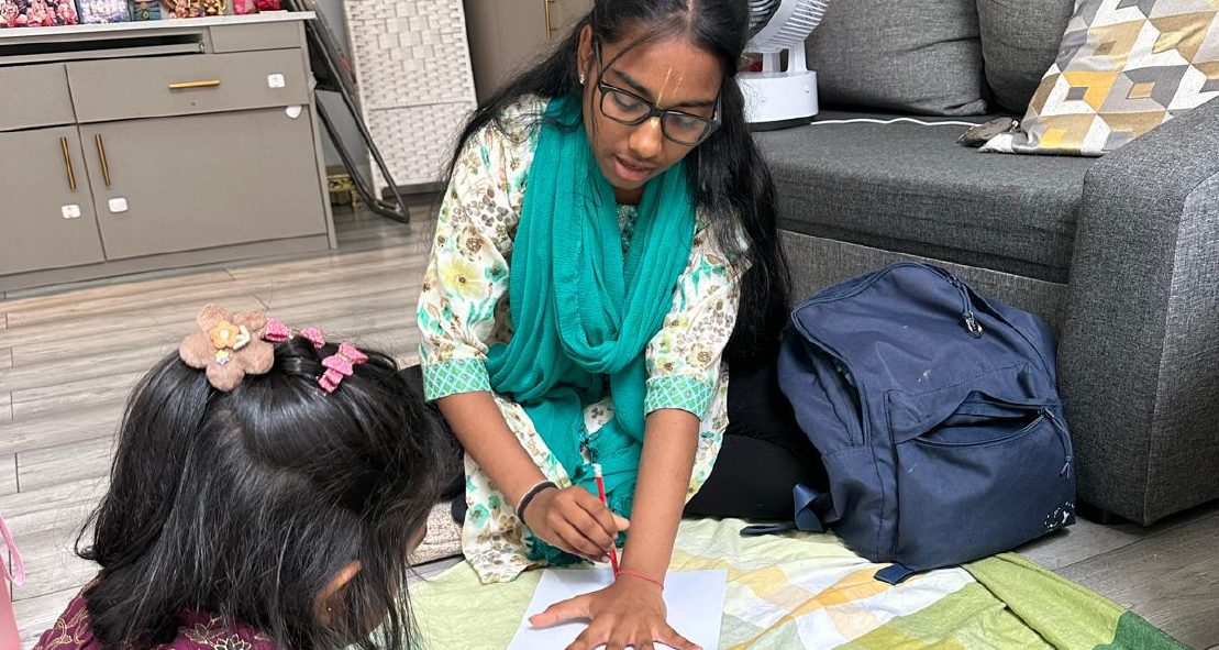 Volunteer helping a child during Toddler Sangha
